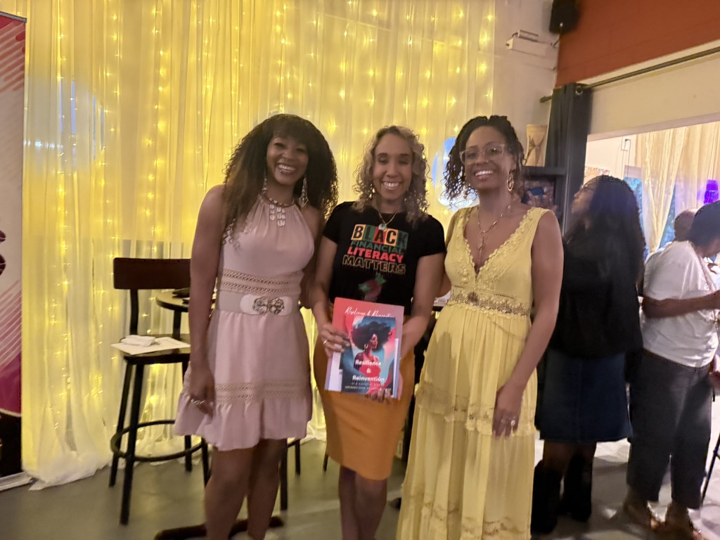 Reader with authors at the Sacramento book launch, holding the book